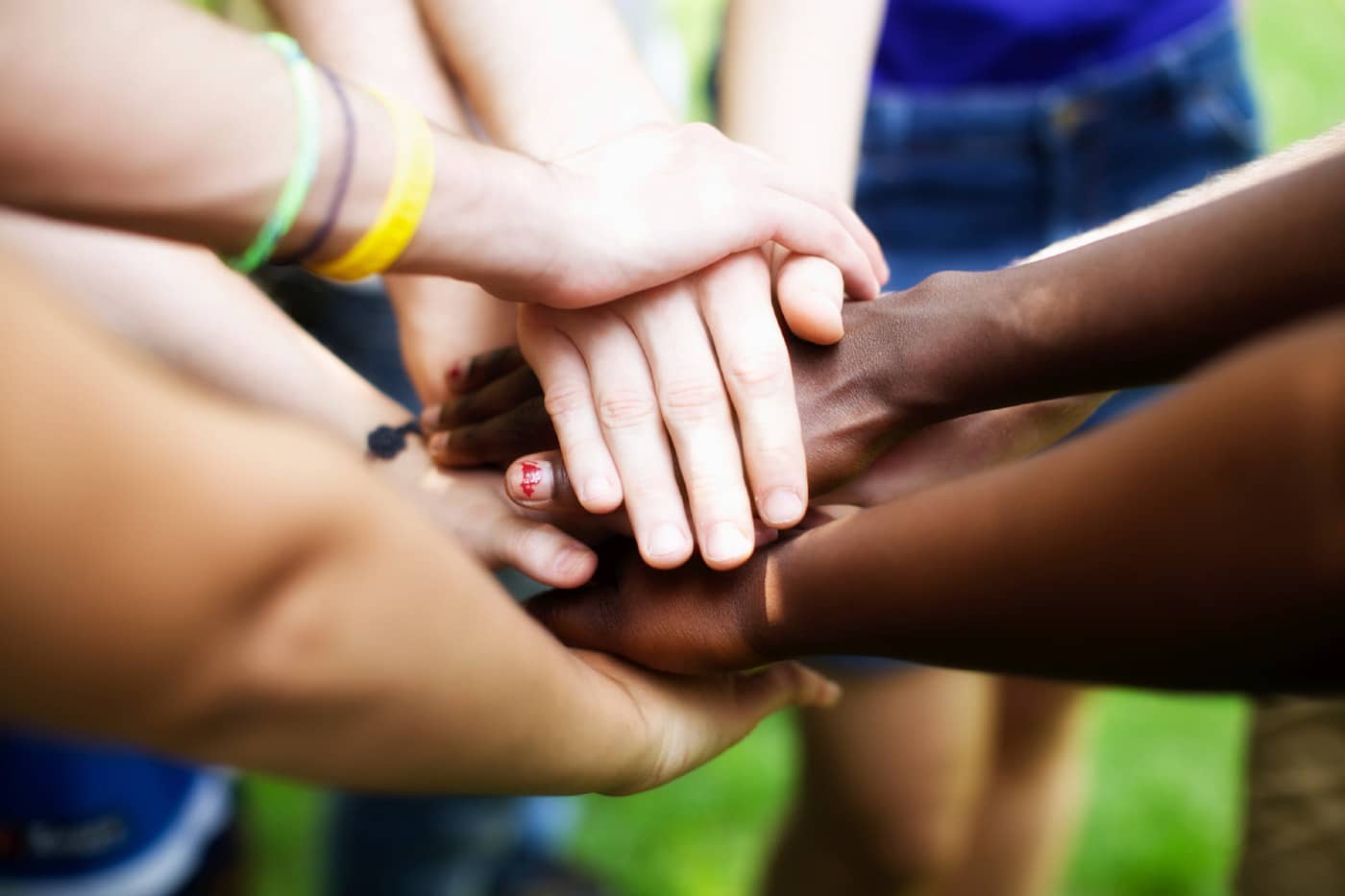 Stock image of people of different races putting their hands in together