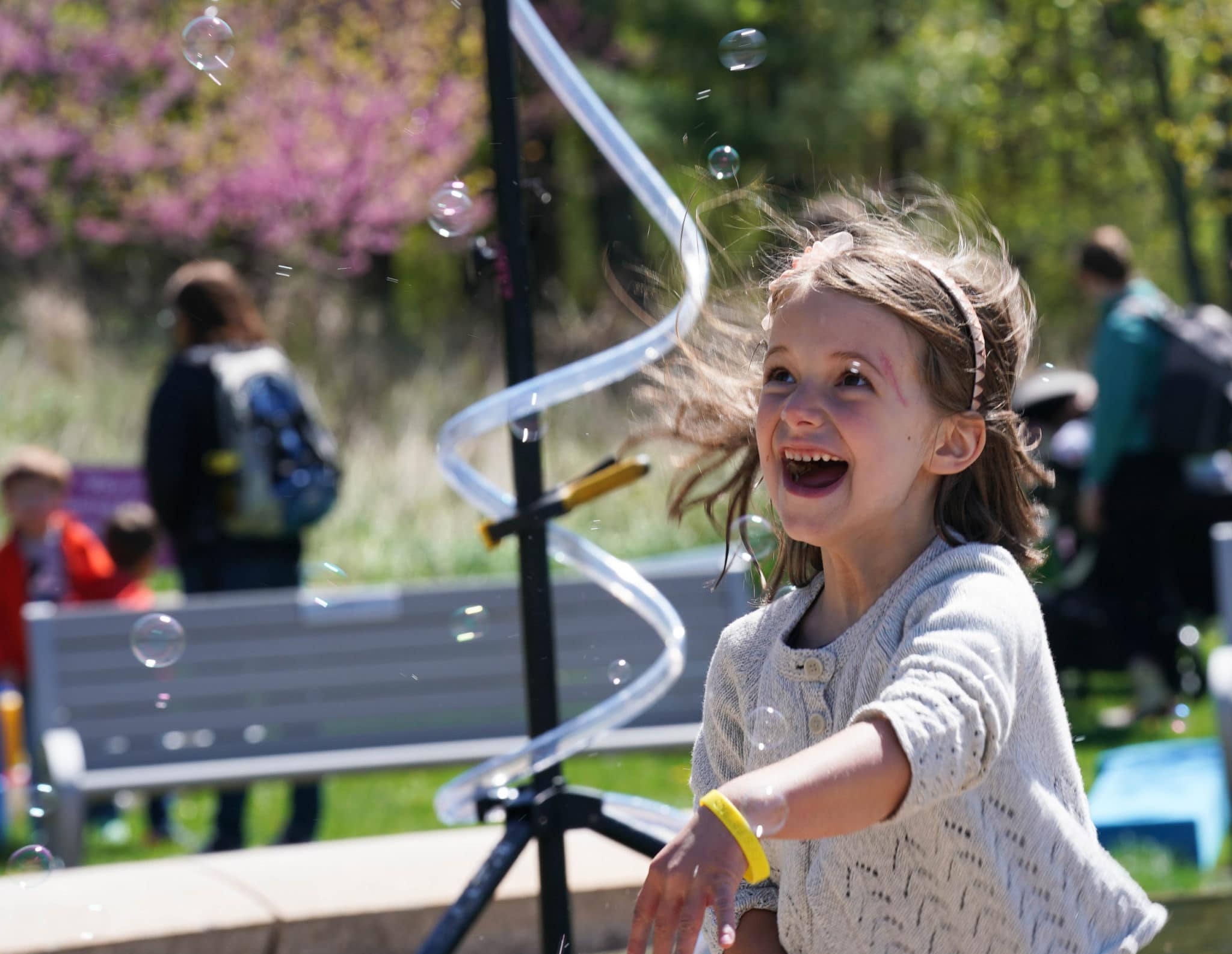 A girl playing with bubbles and smiling
