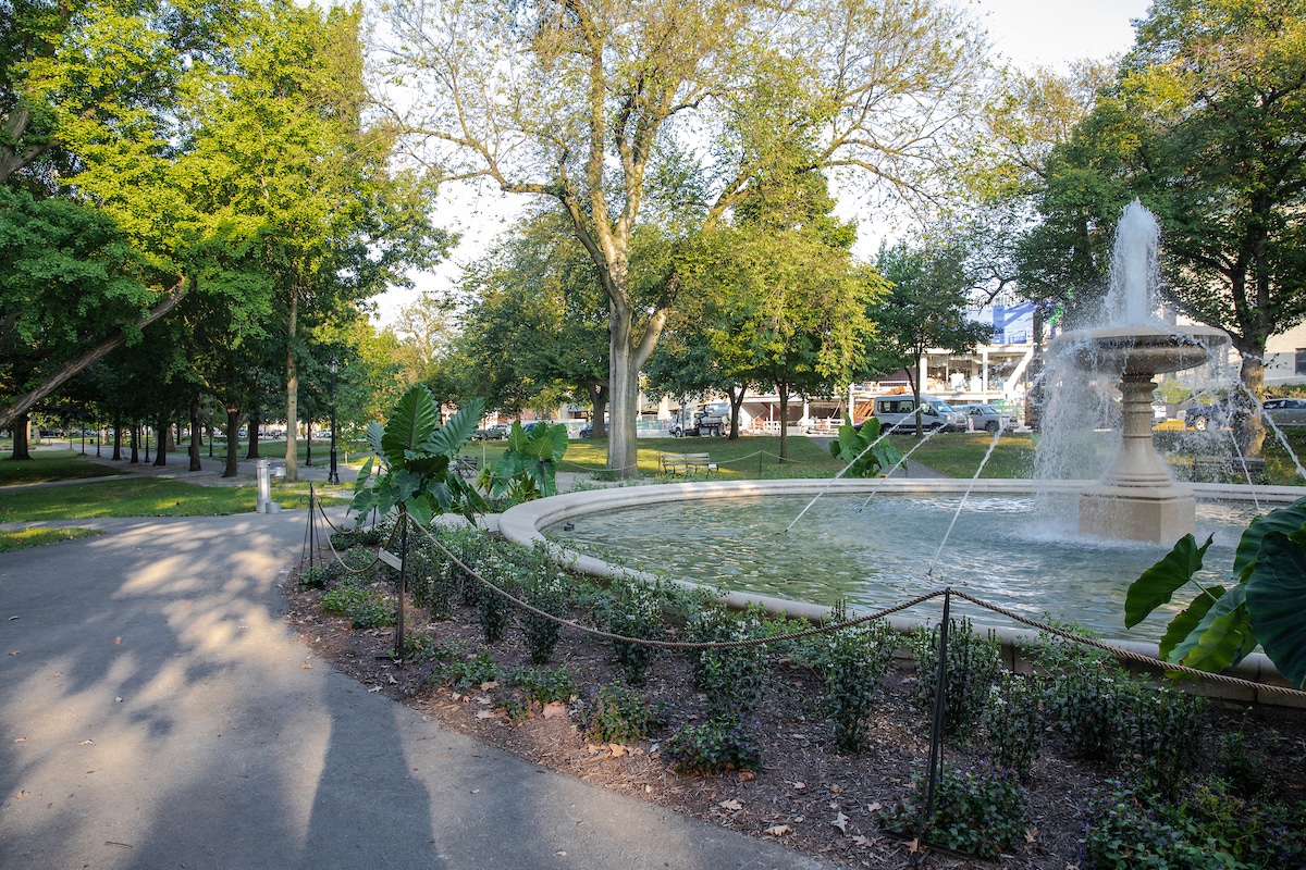 An image of the fountain in Allegheny Commons Park surrounded by trees and benches