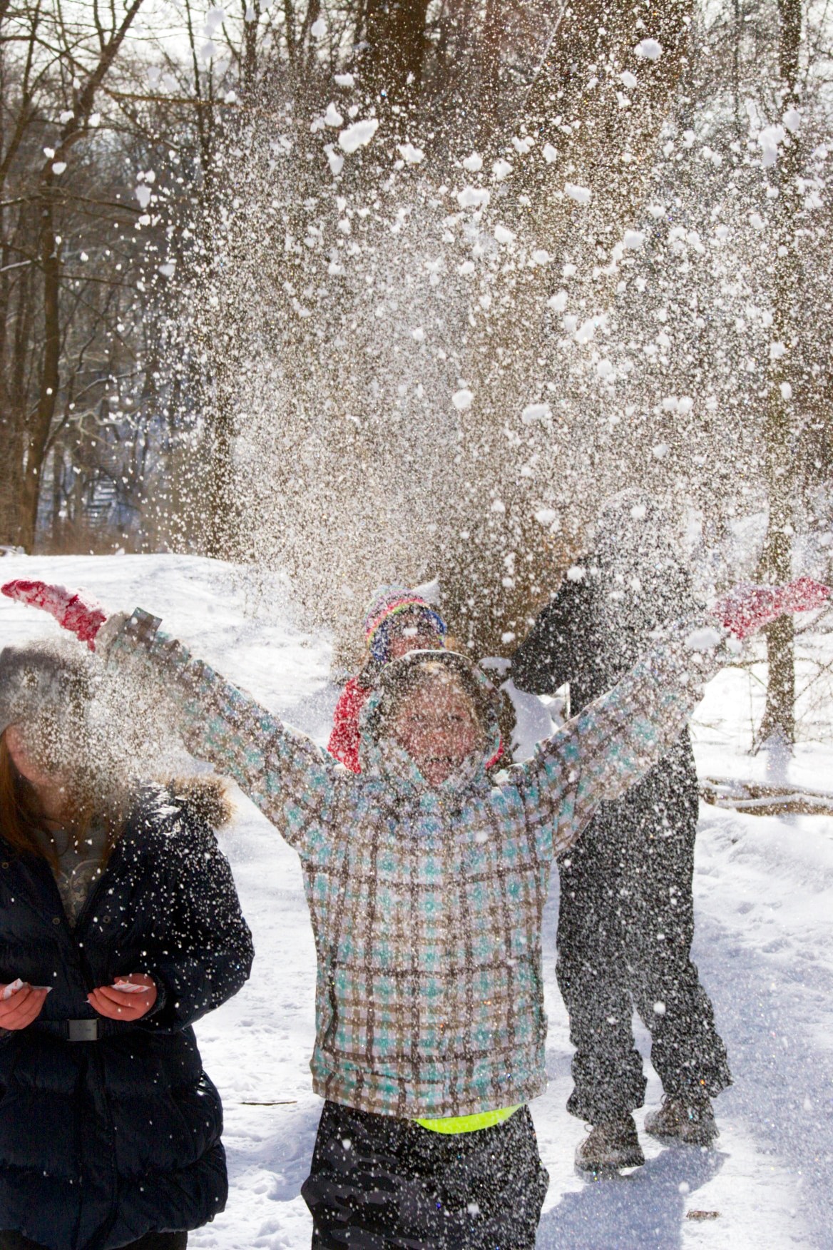 Child throwing snow into the air