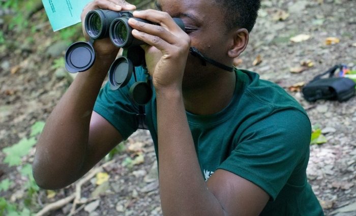 Teen boy looking through binoculars