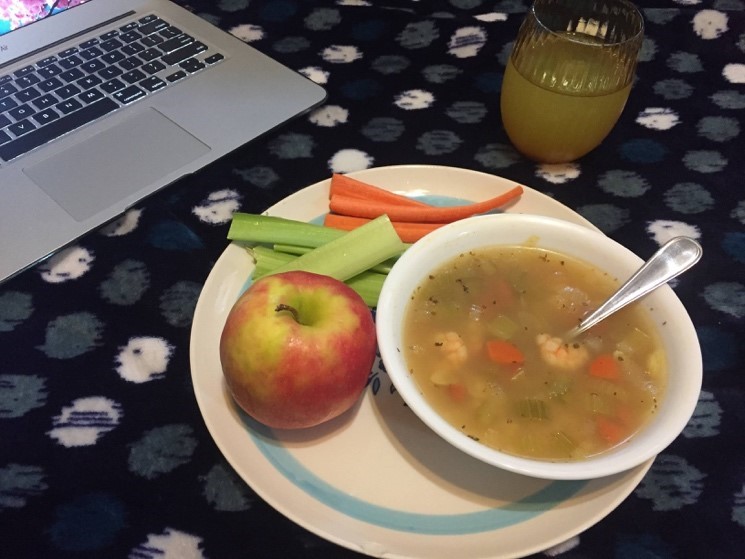 Plate containing soup, apples, celery, and carrots