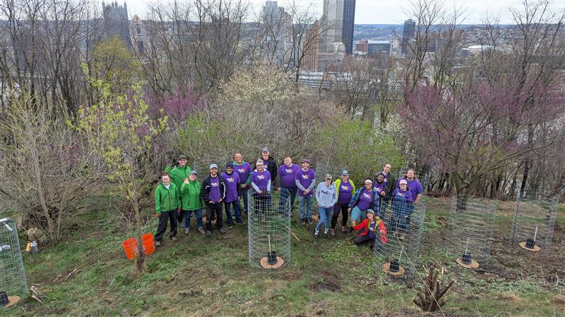 PXL 20250404 153200813 FedEx volunteer pose for a picture at the company volunteer event on April 4, 2025 at Emerald View Park’s Bigbee Field during which 250 plugs and 20 trees were planted.