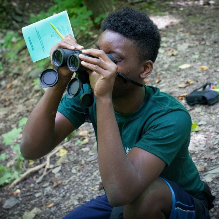 Teen boy looking through binoculars