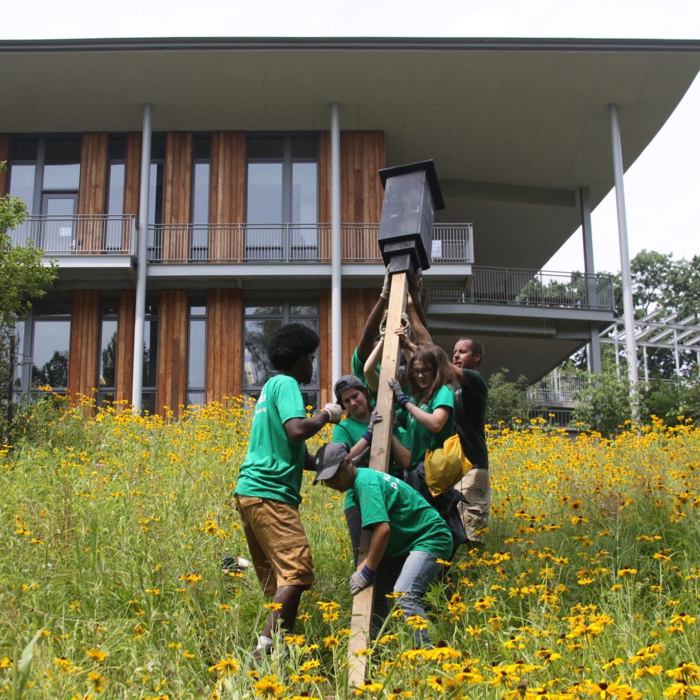 A group of people placing a stake into the ground at Frick Environmental Center
